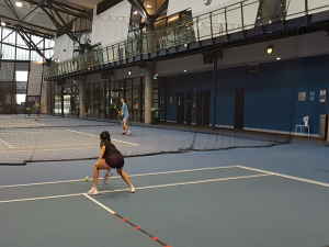 Photo of Blind tennis player playing tennis on indoor tennis court.