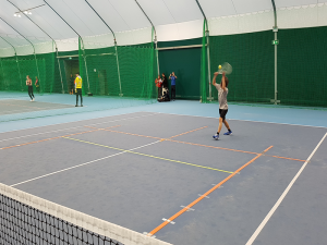 Photo of Blind tennis player playing tennis on indoor tennis court.