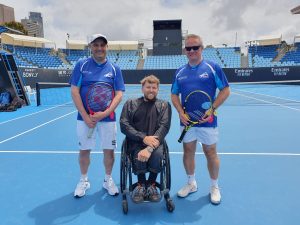 Photo of Australian blind and low visually impaired players Adam Fayad and Robert Fletcher with former world No.1 quad wheelchair player Dylan Alcott on a tennis court at Melbourne Park. Courtesy of Adam Fayad