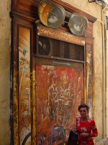 Woman in a red dress walks below a pair of enormous spectacles