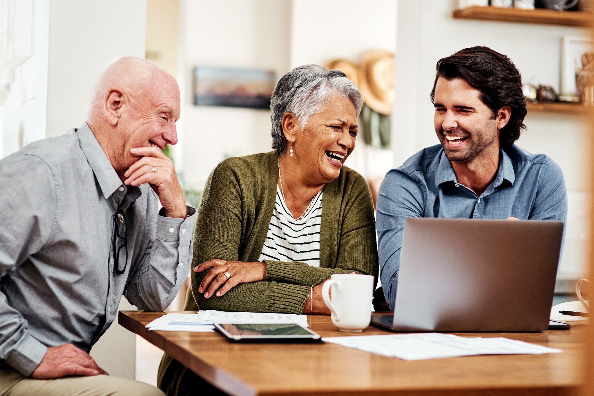Cropped shot of a handsome young businessman sitting and bonding with his senior clients during a meeting in their home