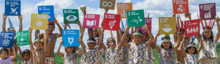 Young peruvian children holding up world goal signs