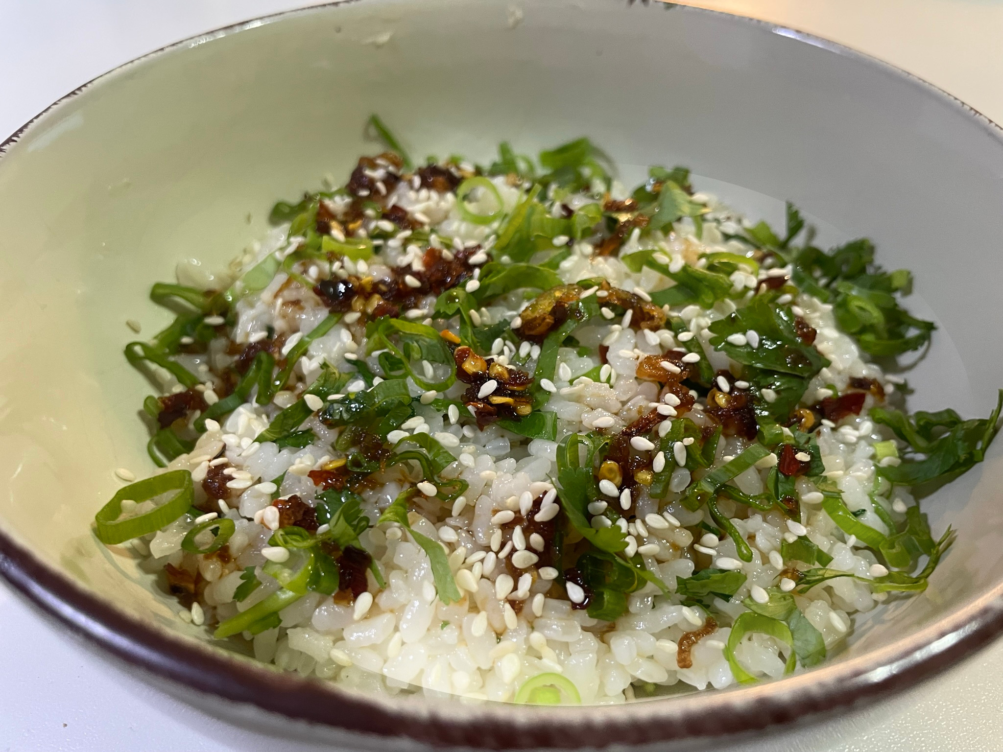a bowl of steamed rice with sesame seeds, homeade chilli oil and raw egg yolk