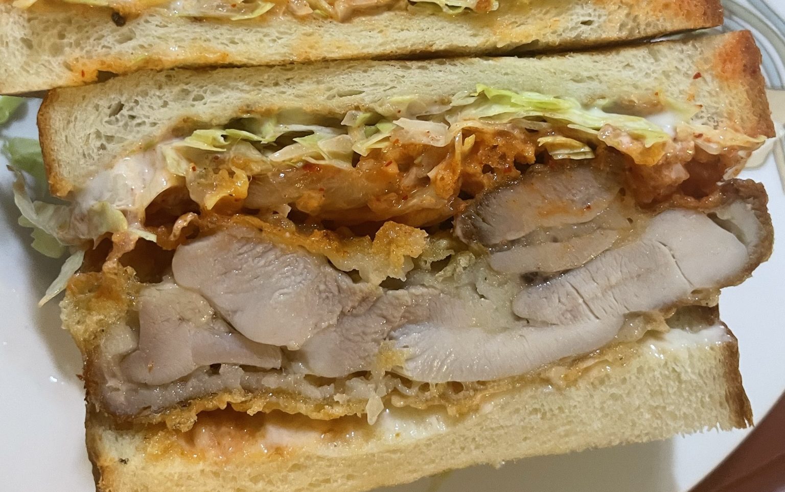 Crunchy and juicy korean fried chicken with kimchi, mayo and lettuce sandwiched between 2 slices of soft milkbread