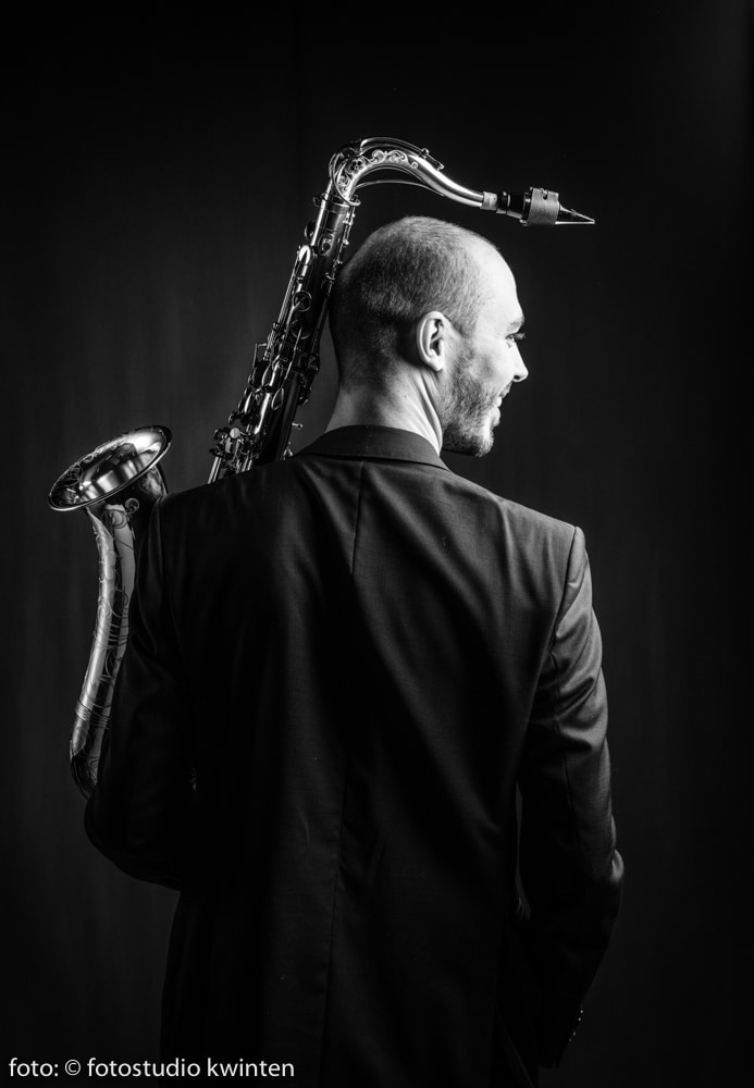 Jeroen Vanbever with tenorsax, smiling, black and white