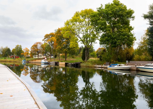 Väddö kanal om hösten där träden speglas i vattnet