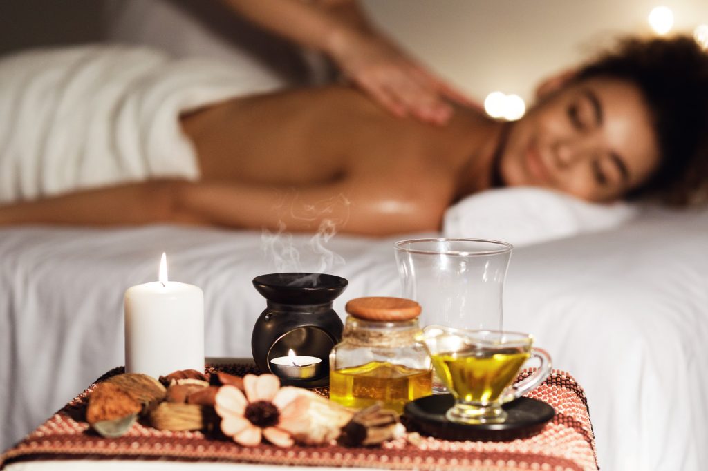 African woman enjoying aromatherapy massage in luxury spa