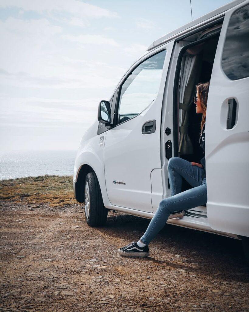 Spootlife - Woman looks out onto beautiful Orkney landscape from a zero emissions tour vehicle