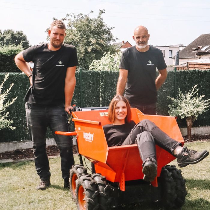 Het team van Juma Tuinen met kruiwagen in een tuin