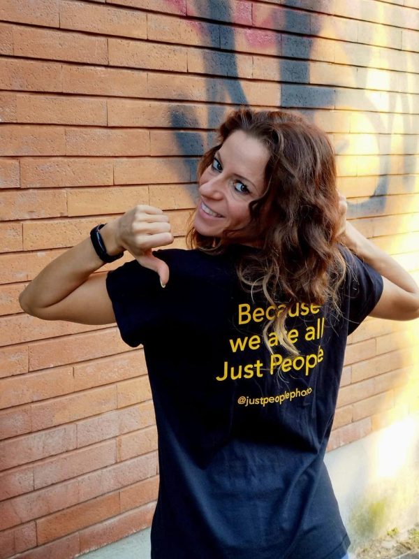 Model wearing t-shirt and pointing with thumbs to the slogan