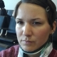 Eine Frau mit kurzen, braunen Haaren trägt eine Halskrause und sitzt an einem Terminal am Flughafen