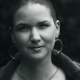 Black and white photo of Karina, a woman with 7 mm shaved hair and huge round earrings.