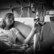 Black and white photo of Jade, a young girl with shoulder-long, blonde hair and a tube up her nose. She faces towards her left hand in which she holds part of her IV