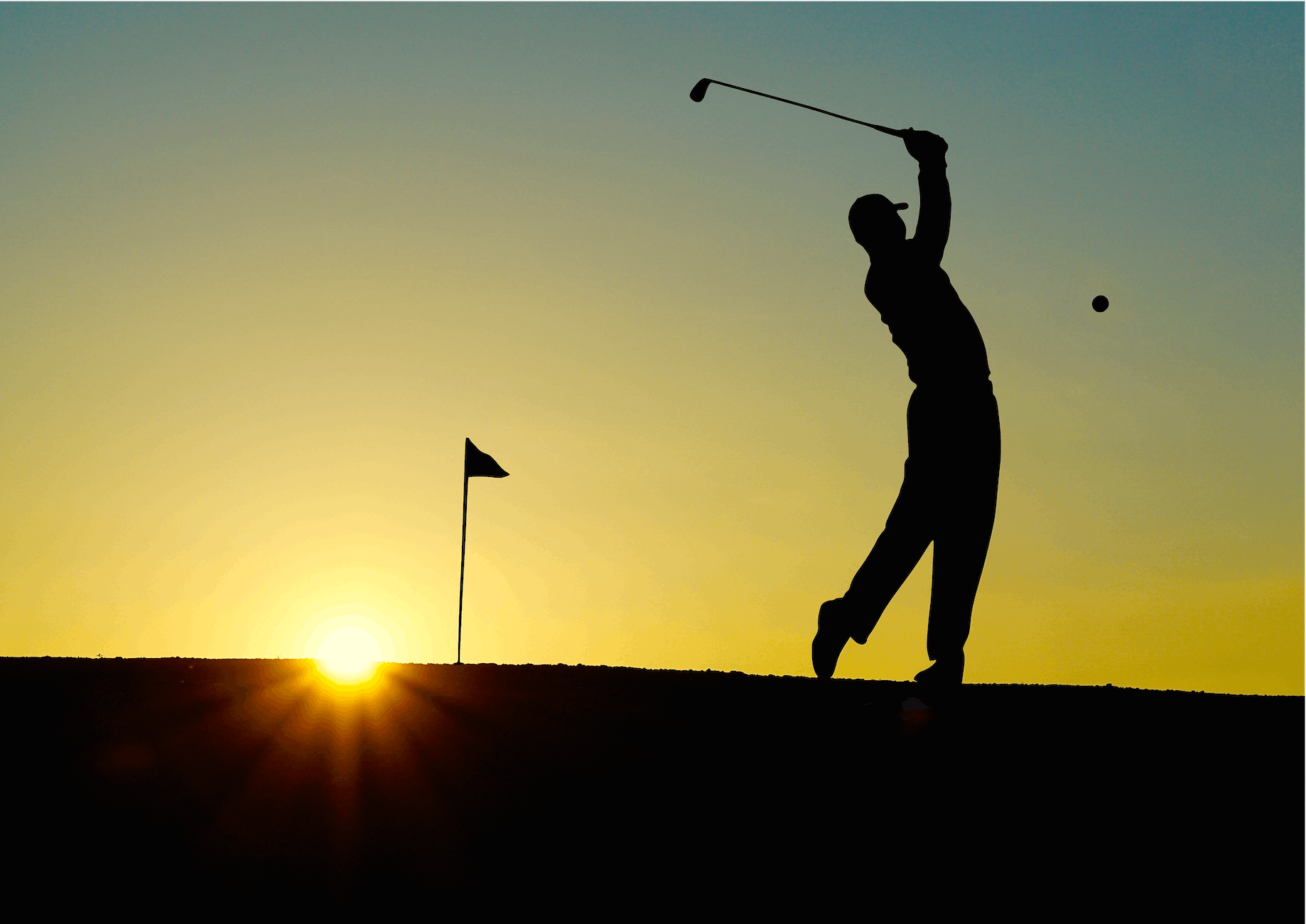 silhouette of man playing golf during sunset