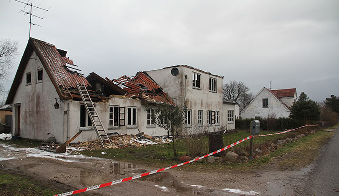 Et udbrændt hus - det er vores hus i baggrunden.