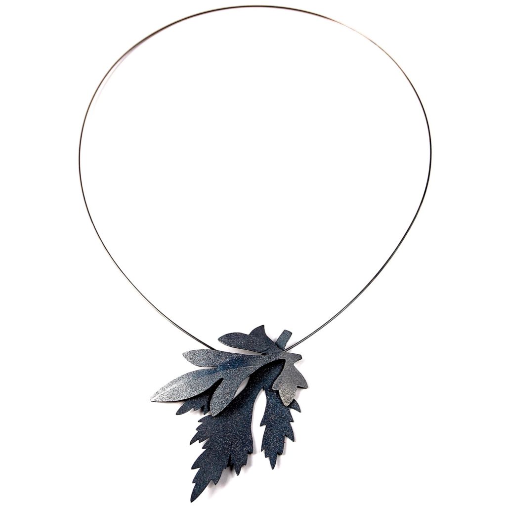 Halssmycke med två ogräsblad på en tunn silvertråd. smycket är tillverkat av silver och har svartoxiderats.