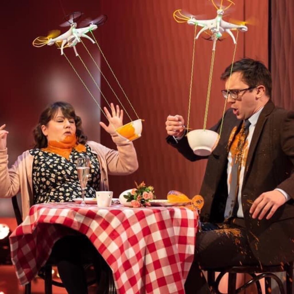 A still from the sketch I was in on Harry Hill's Clubnite. Featuring me and Mat Ewins trying to eat soup out of bowls moving drones. I am drenched in tomato soup.