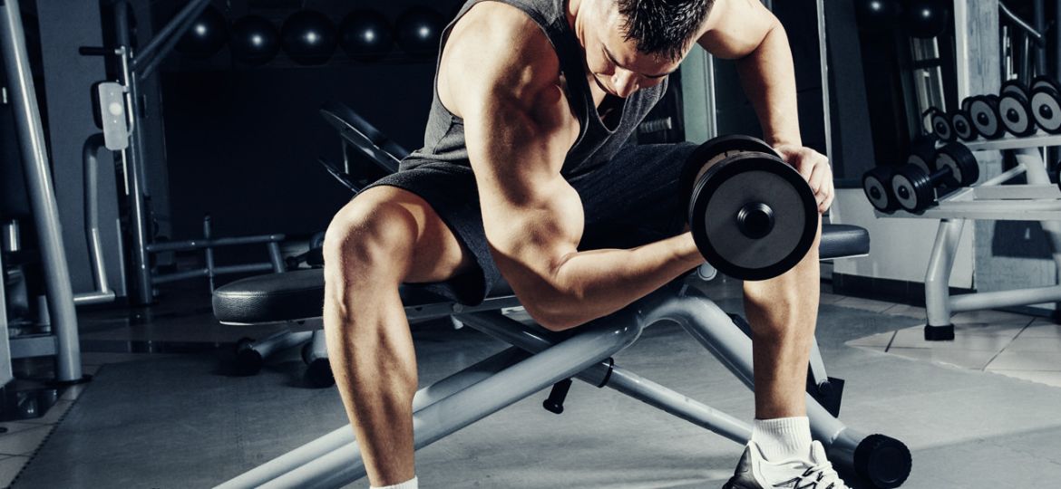 Man met een dumbbell aan het trainen in een sportschool