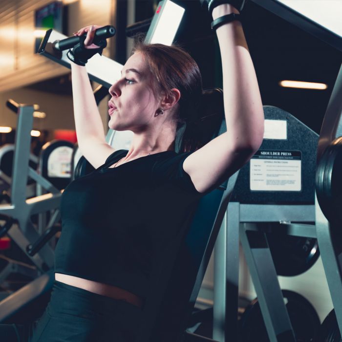 vrouw op een shoulder press