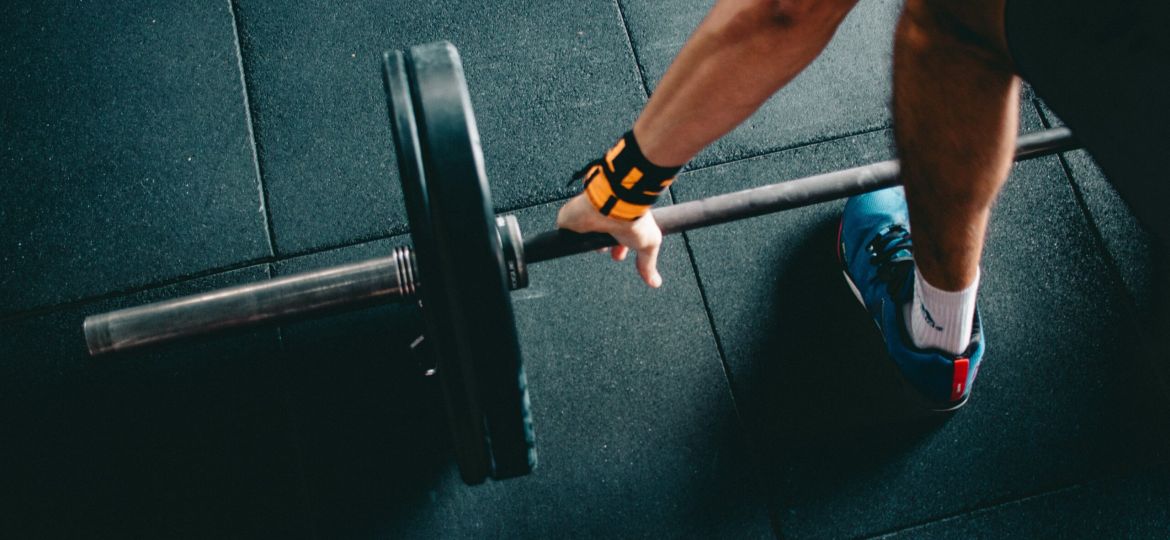 Man pakt barbell op met gewichten