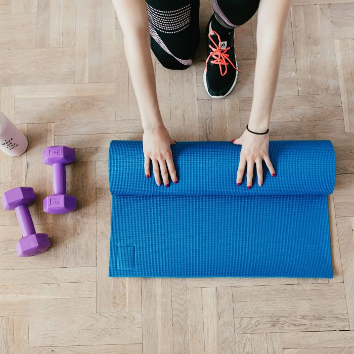 Vrouw met matje en dumbbells