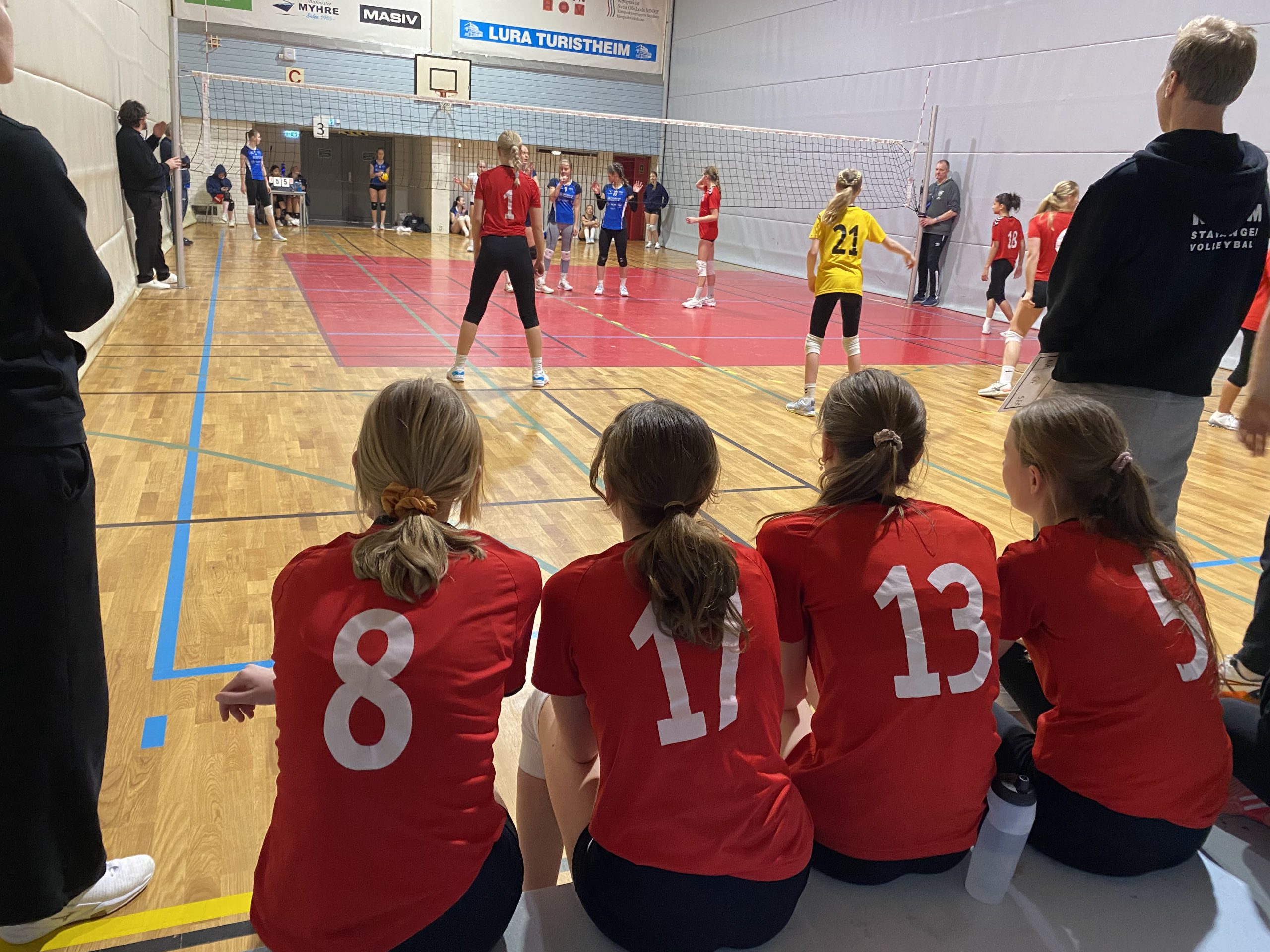 jenter med i volleyballdrakter som ser på volleyballkamp