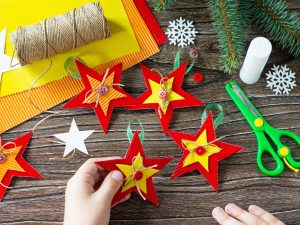A child is holding Christmas tree toys star gift. Handmade.