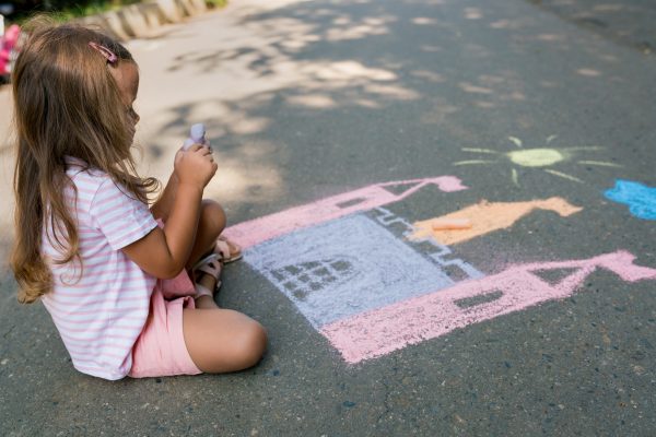 Children chalk drawing a castle outside