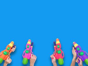 Hands holding gun water toy on blue background.