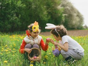 Two children hunt for Easter eggs in a spring garden. Easter tradition