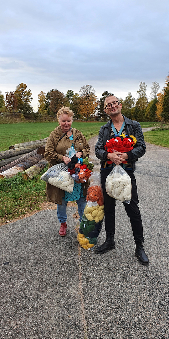 Två glada deltagare på tuftkursen har massor av nyhandlat garn i famnen