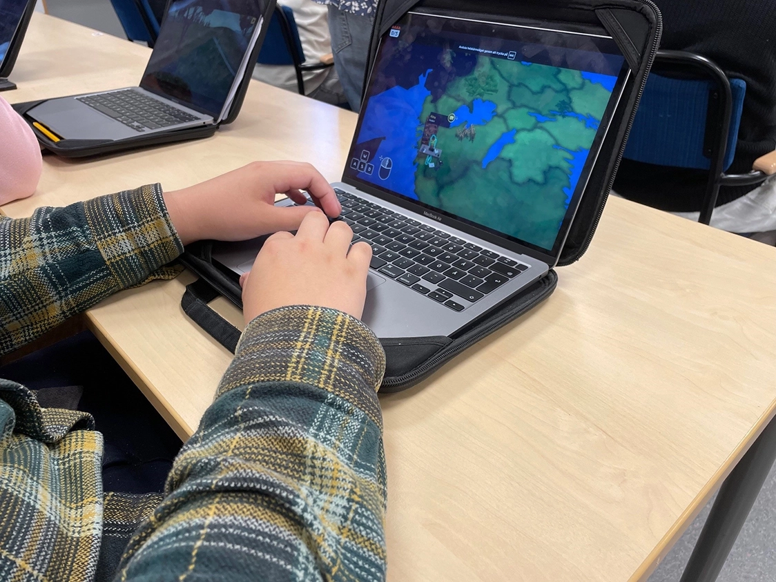 En student tittar på en laptop-skärm som visar klimatspelet utbildningsspel.