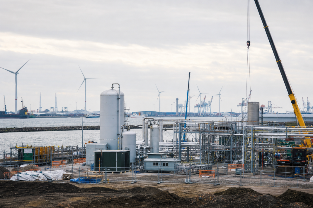 AI-gegenereerde illustratieve foto van een industrieel waterstofproject in aanbouw bij een haven.