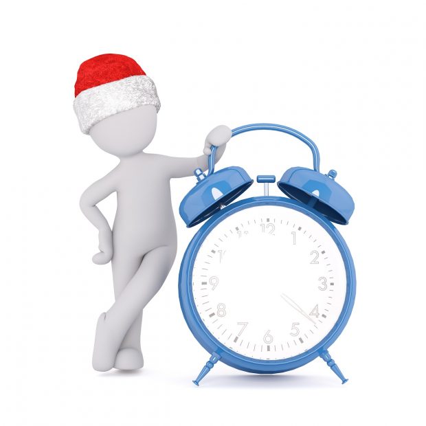 Man with Santa hat relaxing by clock 