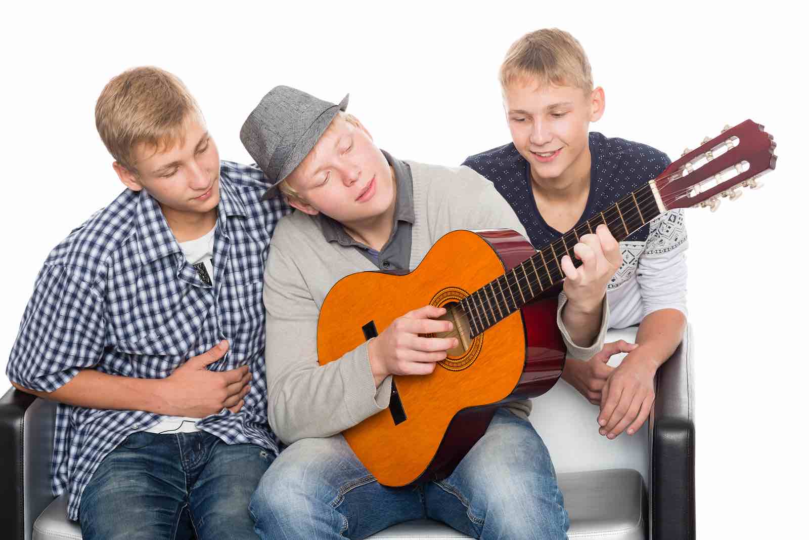 Tre gutter spiller gitar og synger