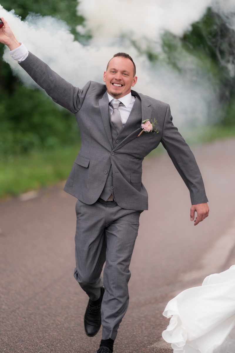 Brudgum som springer med en rökelse. Bröllopsfotograf Langes Fotografering i Motala.