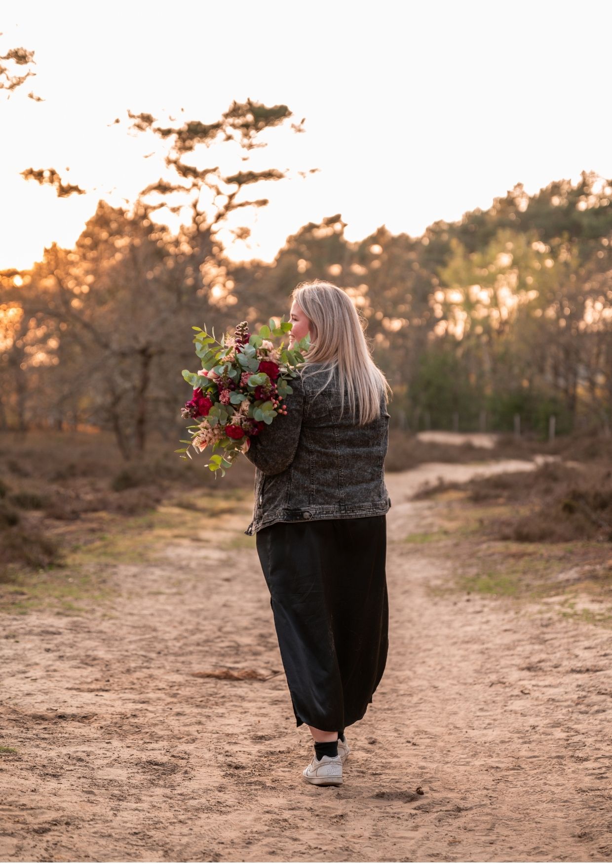 Dorien van Kontent stapt weg met een bos bloemen in de natuur