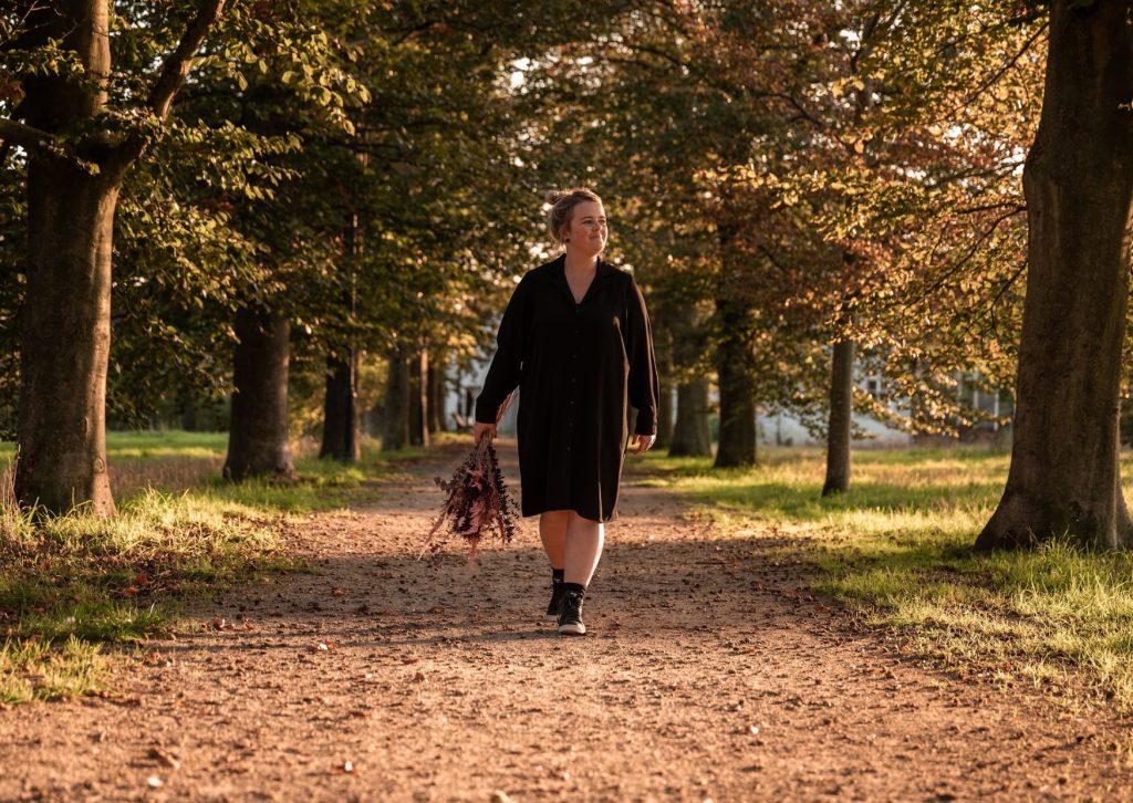 Dorien wandelt met een bos verse bloemen door de natuur
