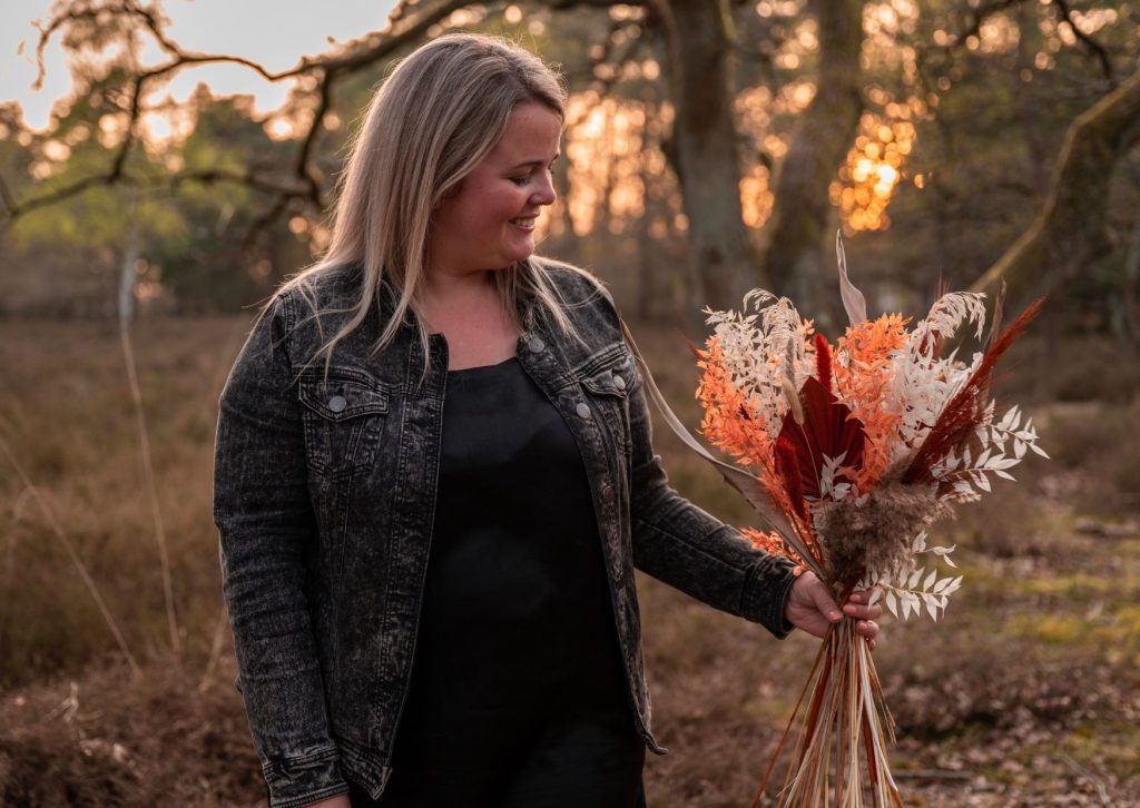 Dorien van Kontent houdt een boeket droogbloemen vast in de natuur