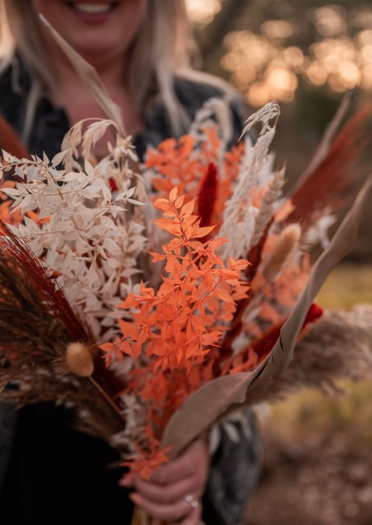 Close up van Dorien van Kontent die een boeket droogbloemen vasthoudt