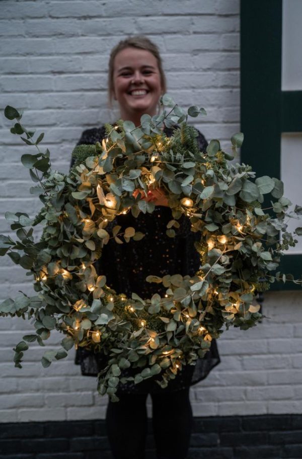 Dorien van Kontent houdt een krans met Eucalyptus vast