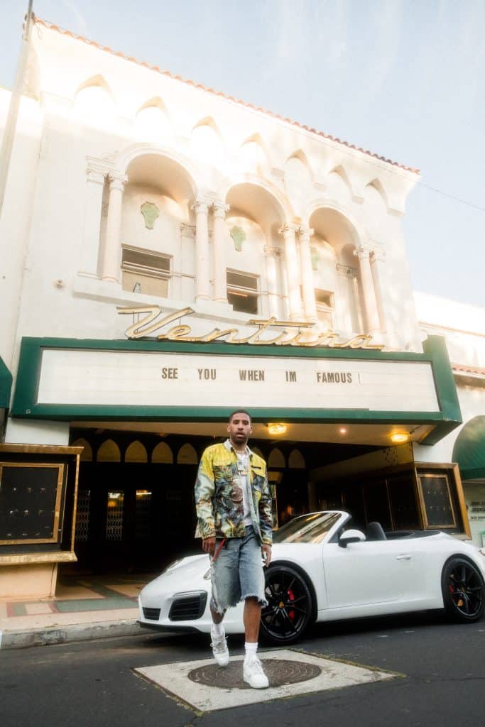 Famous influencer posing with a luxury car