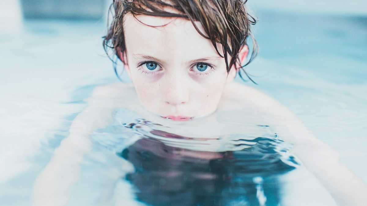 selective focus photography of boy floating on water