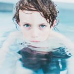 selective focus photography of boy floating on water