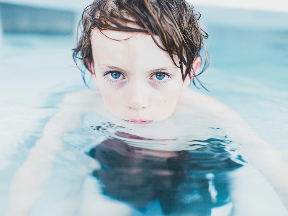 selective focus photography of boy floating on water