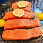 Lachs mit Salz. Pfeffer würzen und eine Zitronenscheibe auf das Filet legen und