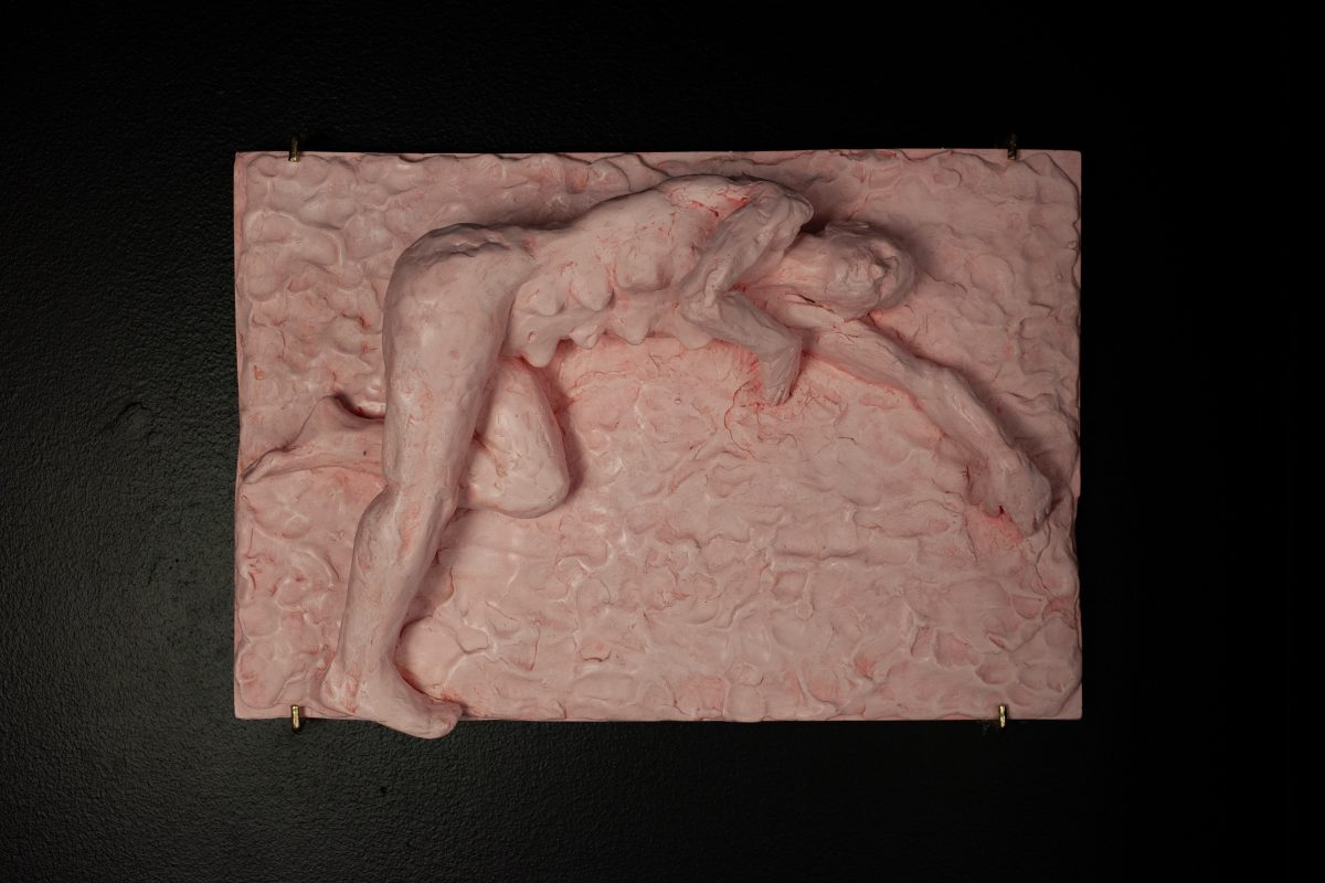 A wall sculpture made from Jesmonite and pigment showing a woman