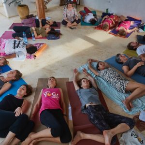 Participants meditating while lying down in a yoga retreat