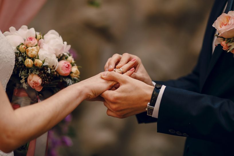 Novios boda poniendose las alianzas de plata para ahorrar dinero boda