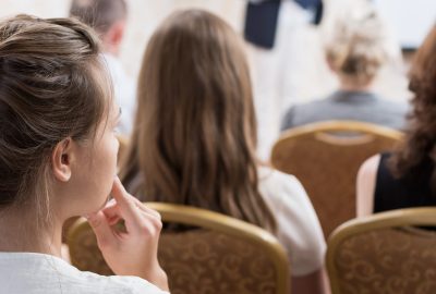 Young woman is listening at the conference